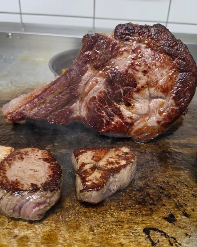 Tomahawk-Steak und Filets auf der Grillplatte